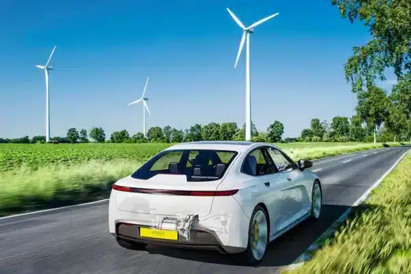 Foto de un coche eléctrico cerca de una zona de energía eólica